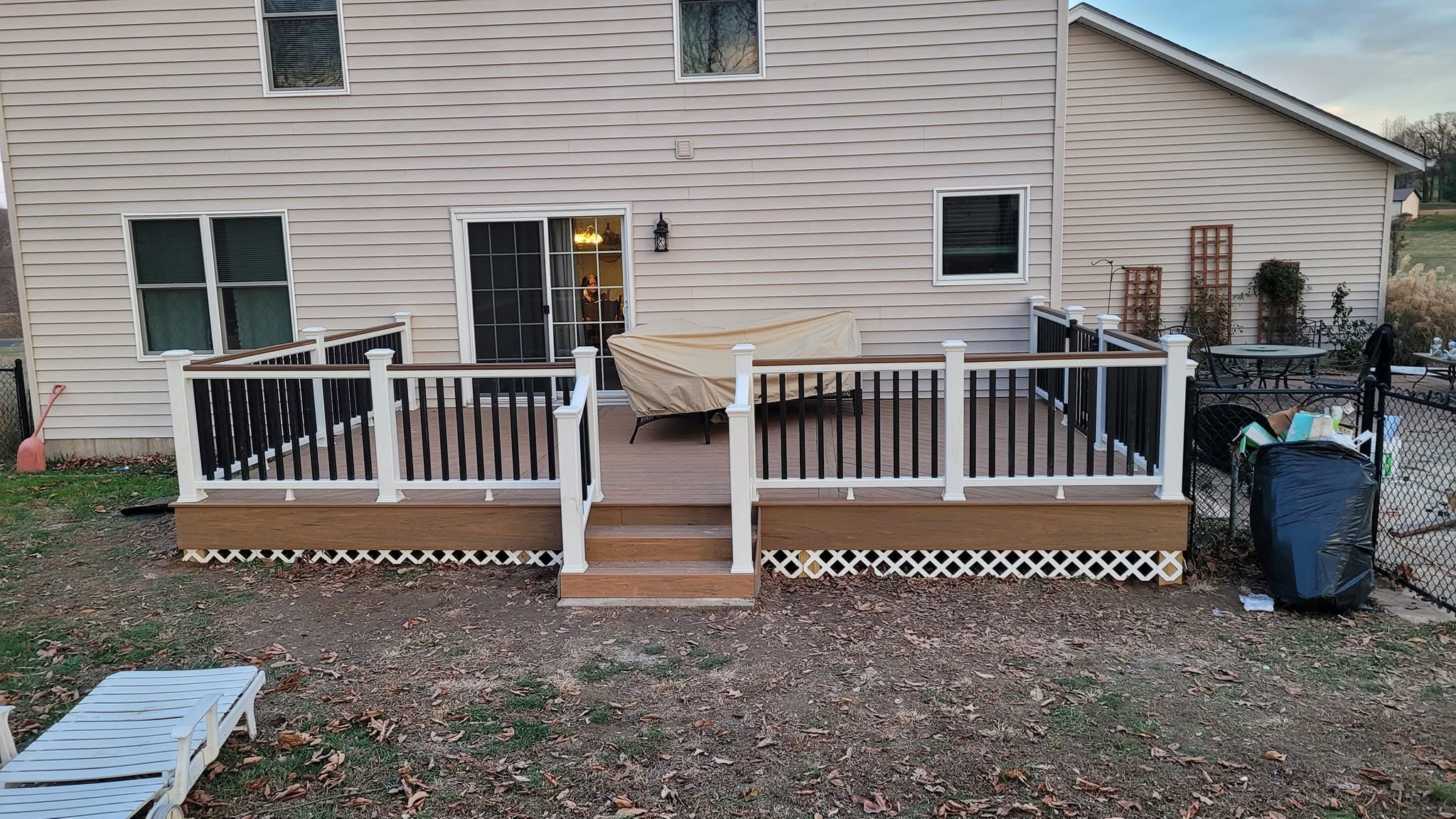 Newly built residential deck with white posts and black railing balusters